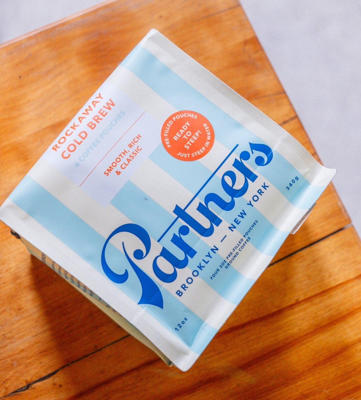 Partners Coffee image for The Story Behind Rockaway blog post. This image depicts a bag of Rockaway Cold Brew Pouches displayed against a wooden cutting board