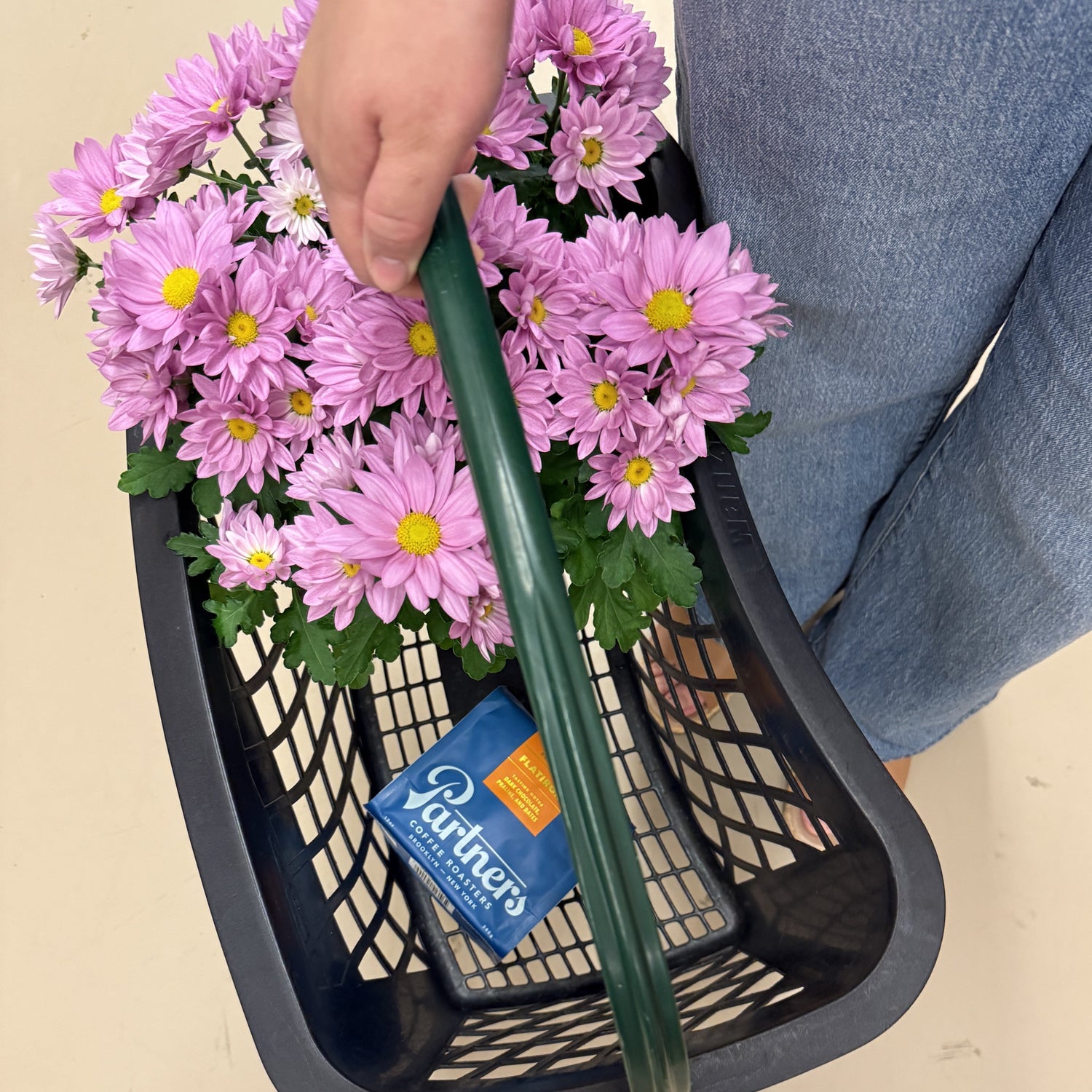 Partners Coffee image for Fresh Thyme Market. This image displays a bag of Flatiron in a Fresh Thyme Market shopping basket with pink flowers