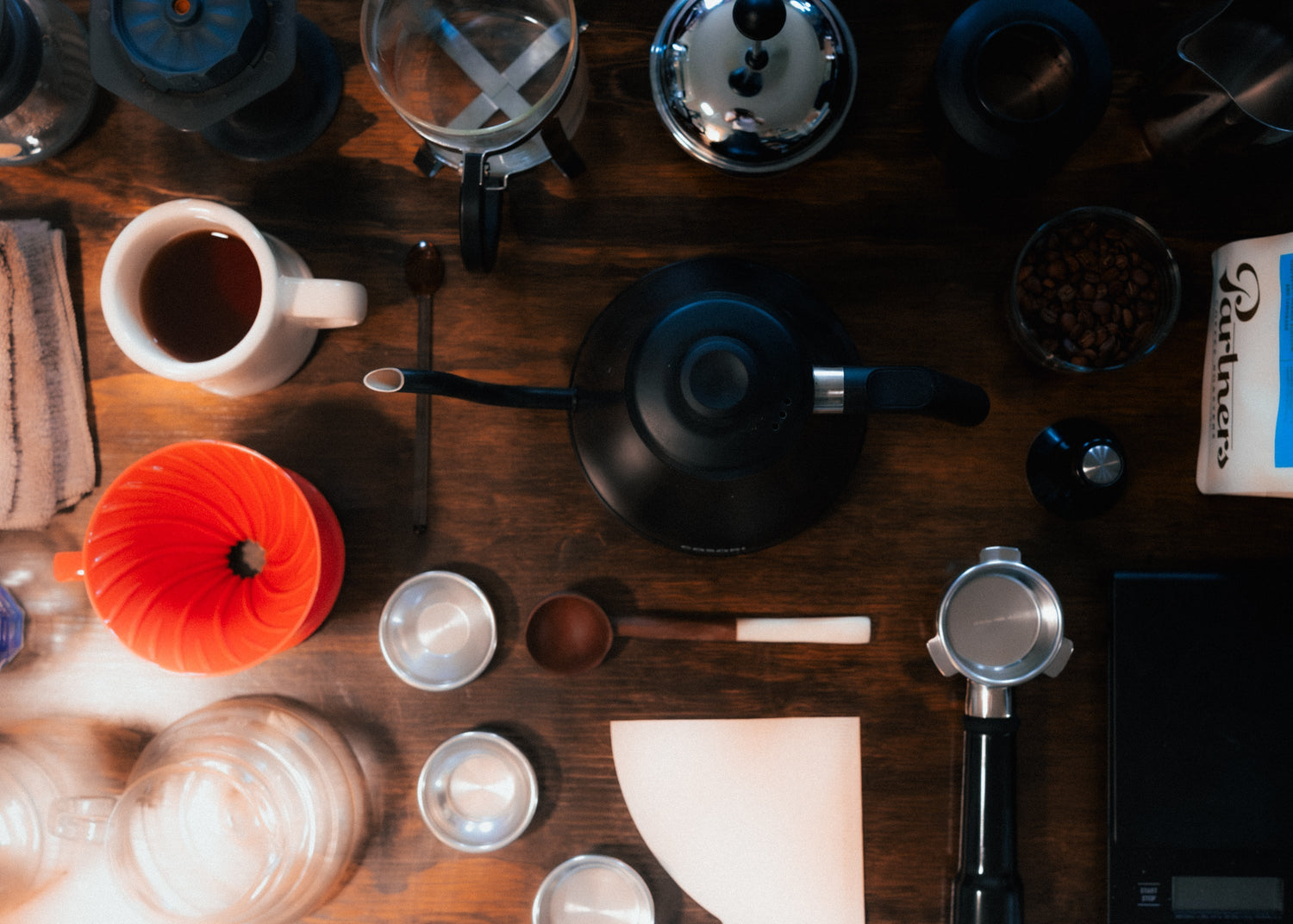 Image for Partners Coffee "Our Favorite Coffee Accessories" blog post. This image depicts various brewing equipment and coffee gear