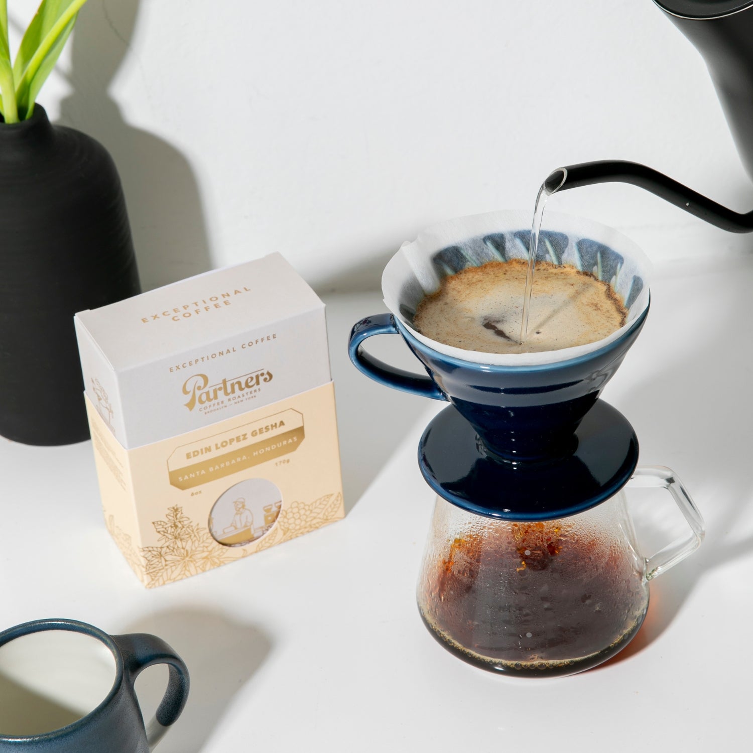 Partners Coffee image for Edin Lopez Gesha Brew Guides blog post. This image depicts a box of Edin Lopez Gesha next to a brewing V60 pour over