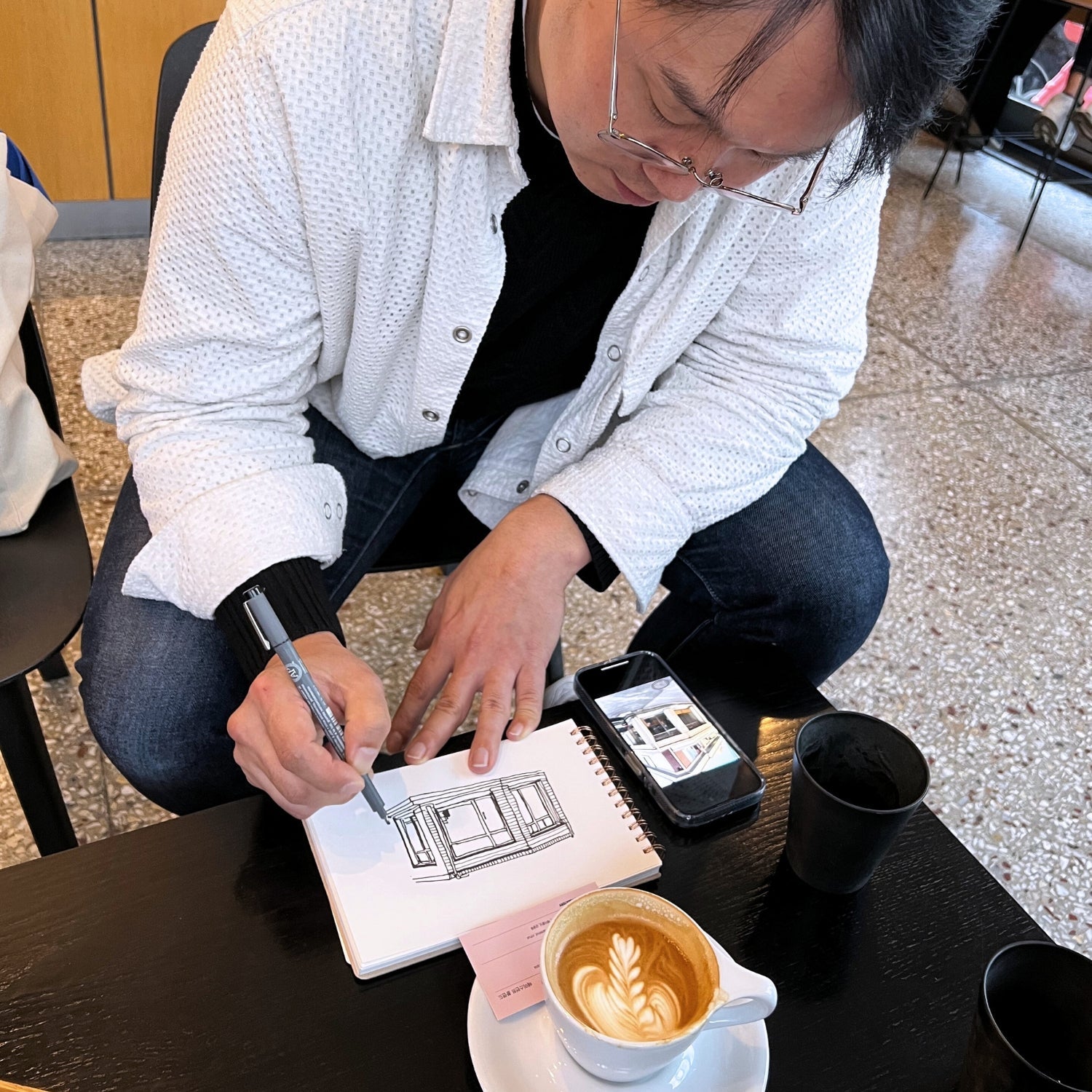 Artist Moonsub illustrating an image of a cafe storefront